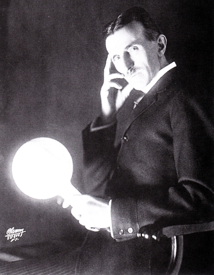 Imagem de Nikola Tesla segurando sua lâmpada de descarga ou fluorescente